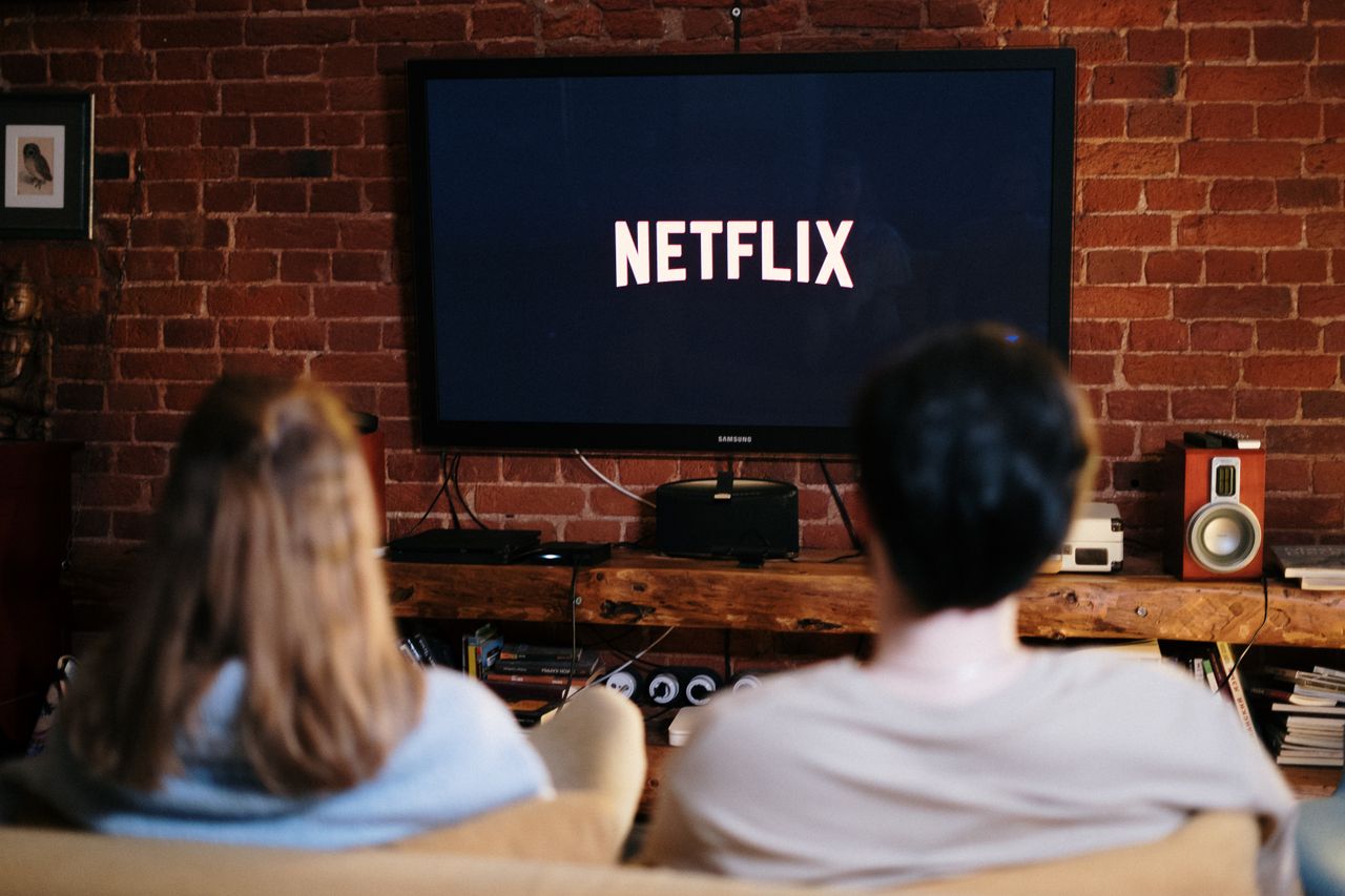 About A couple relaxing and watching Netflix in a cozy living room setting.