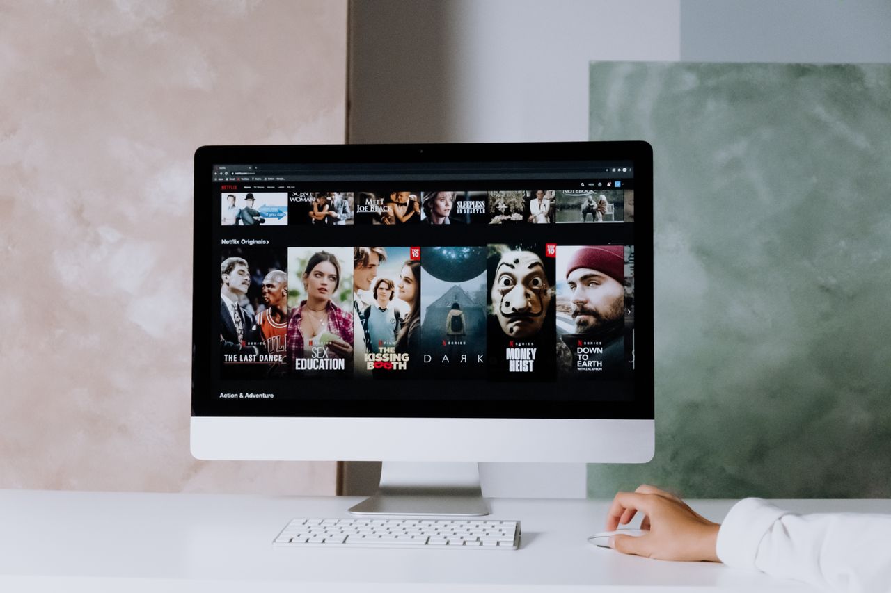 Services A modern workspace featuring a desktop screen displaying popular streaming series on Netflix.