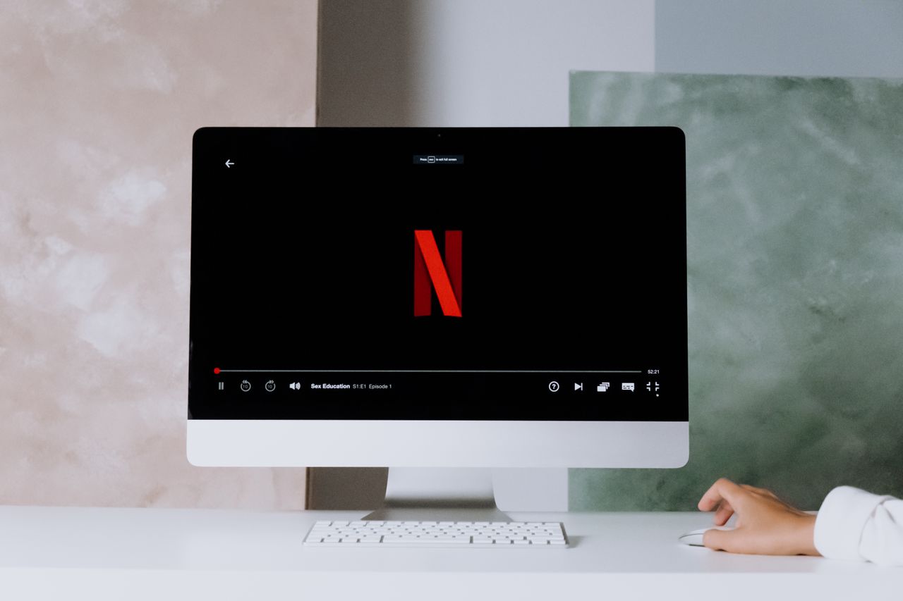 About A minimalist workspace scene featuring a desktop displaying a streaming service, ideal for modern lifestyle themes.